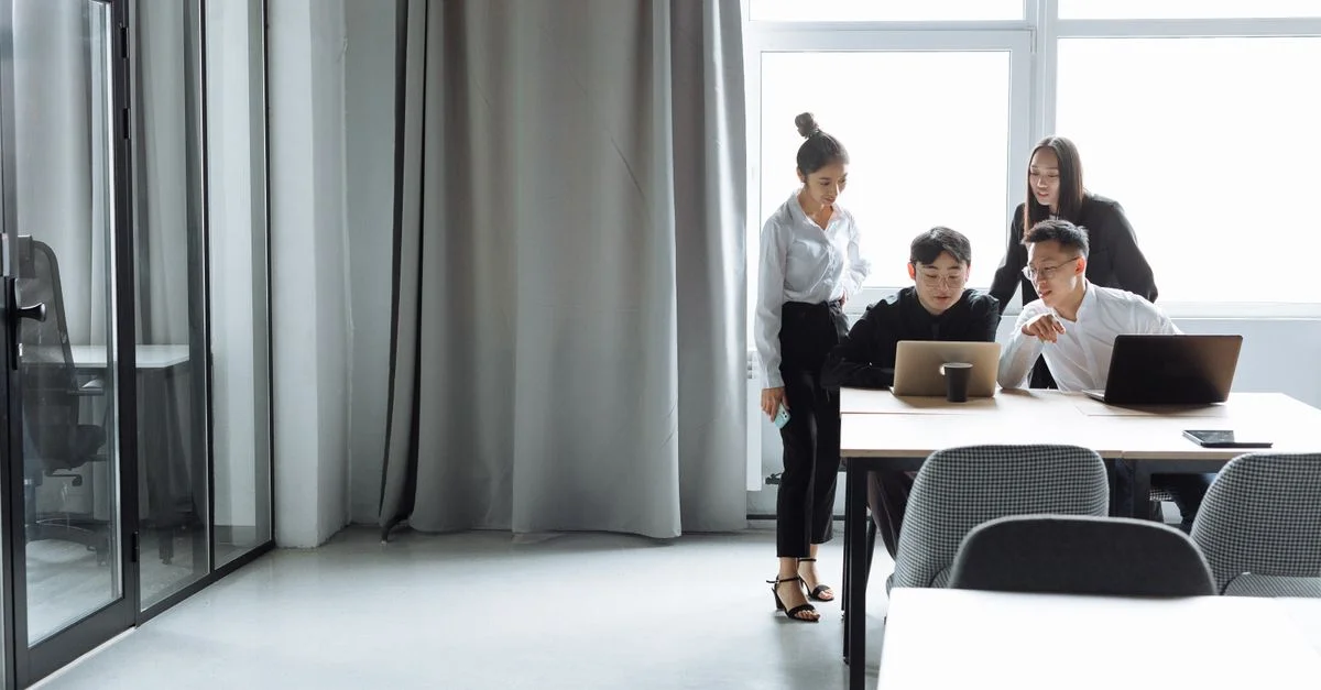 Une équipe de bureau diversifiée collaborant sur des ordinateurs portables pendant la journée.