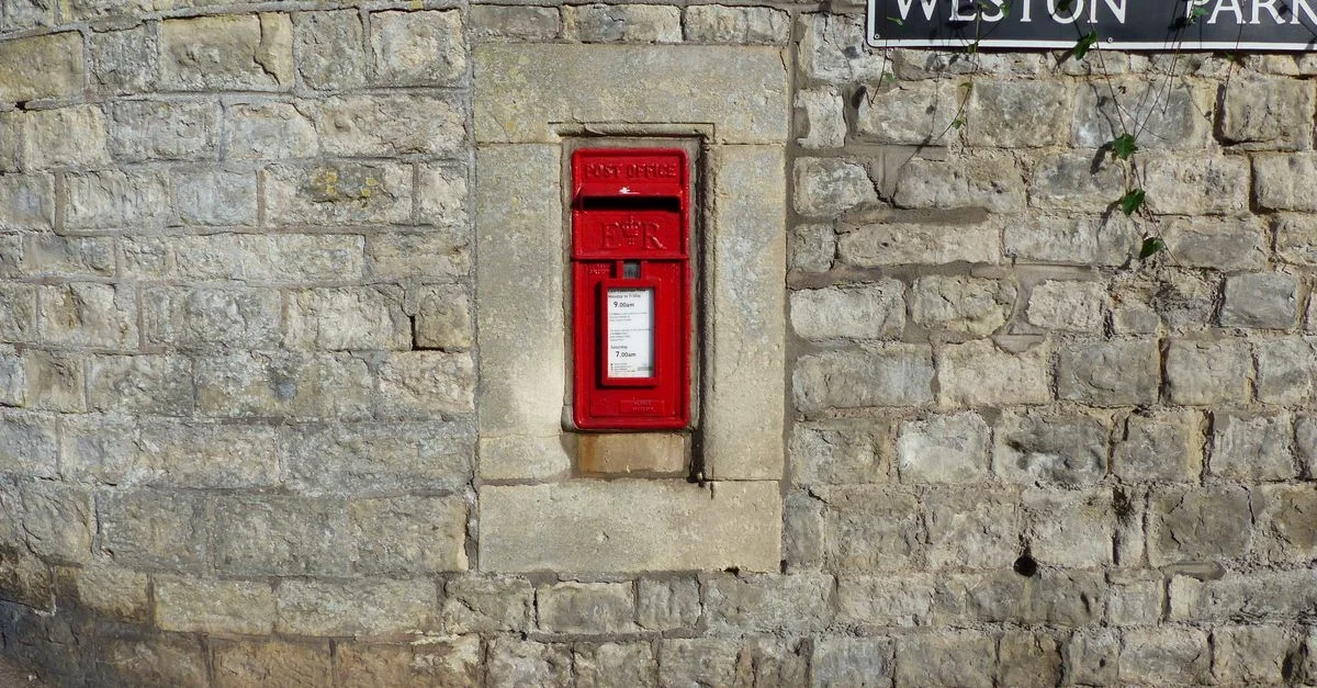 Une boîte aux lettres rouge classique encastrée dans un mur en pierre à Weston Park, Bath, Royaume-Uni.