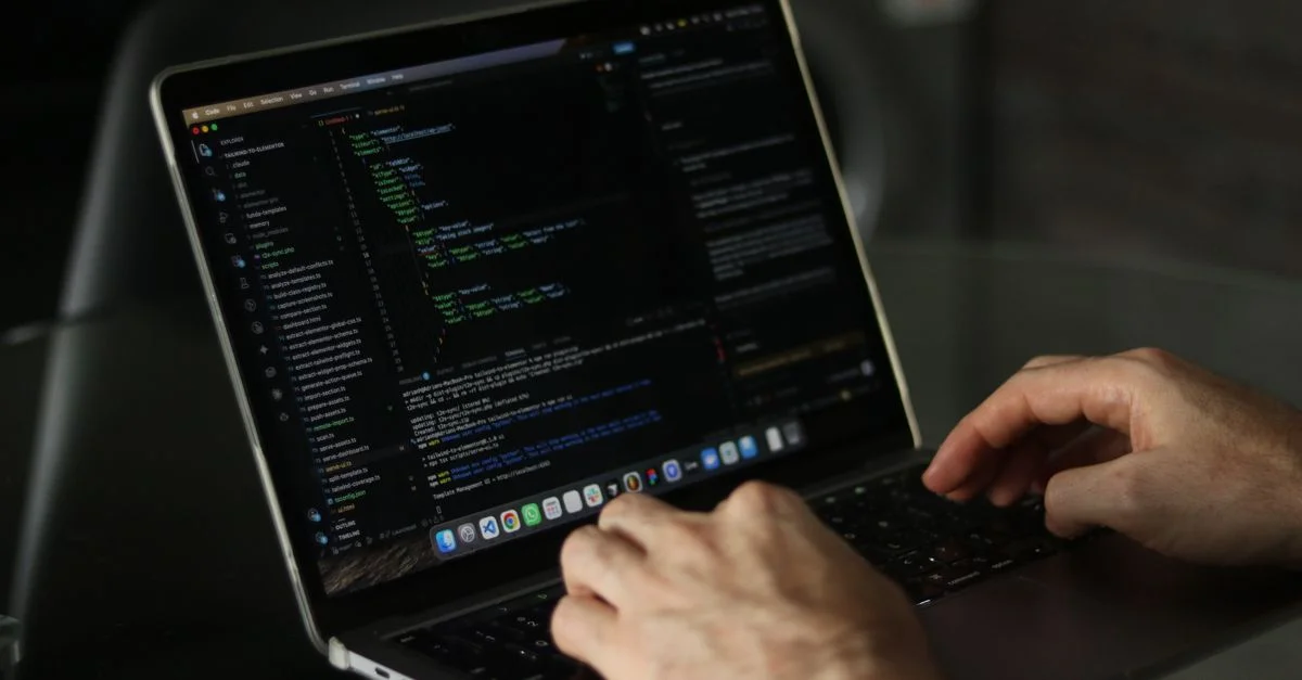 Gros plan sur des mains codant sur un ordinateur portable, mettant l'accent sur la productivité en programmation.