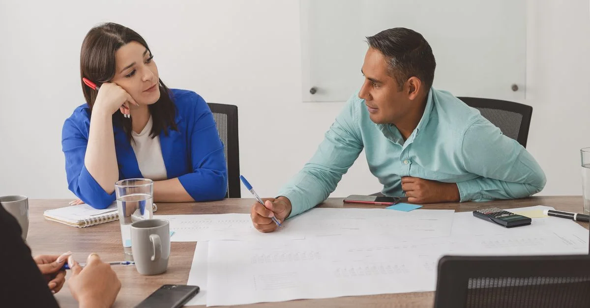 Des professionnels en affaires participant à une réunion productive dans un espace de travail moderne.