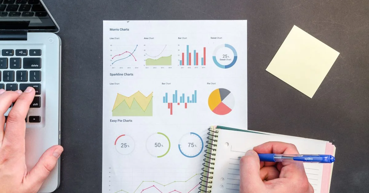 Mains interagissant avec des graphiques et des notes pour l'analyse des données sur un bureau.