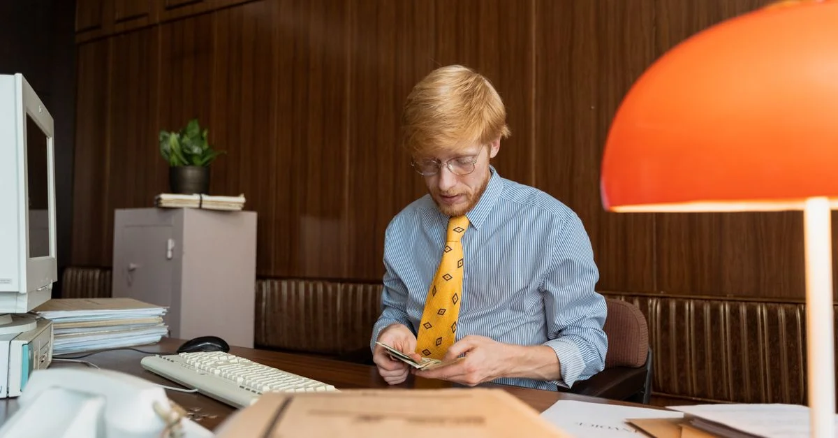Homme d'affaires dans un bureau rétro comptant de l'argent à son bureau.