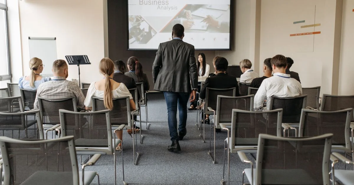 Cadre de conférence d'affaires avec des participants divers se concentrant sur la présentation d'analyse.