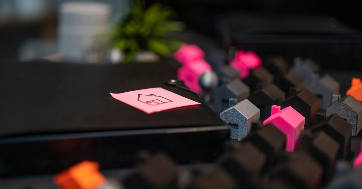 Gros plan de maisons miniatures et d'un croquis de maison sur un post-it, symbolisant des concepts immobiliers.